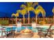 Relaxing poolside view with a fire pit, waterfall features, and lush palm trees at 5904 E Calle De Las Estrellas Rd, Cave Creek, AZ 85331