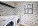 Bright laundry room with modern washer, dryer, and unique dandelion-themed wallpaper at 6325 N 83Rd Pl, Scottsdale, AZ 85250