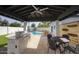 Outdoor kitchen featuring a dining area, grill, and view of the sparkling pool, ideal for outdoor gatherings at 6325 N 83Rd Pl, Scottsdale, AZ 85250