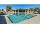 Community pool with ample lounging and shade, with a building that provides restrooms and changing rooms at 6711 E Camelback Rd # 43, Scottsdale, AZ 85251