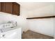 Functional laundry room features a washing machine, upper cabinets and an additional wall shelf at 737 W Jones Ave, Phoenix, AZ 85041