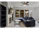 Stylish living room featuring a fireplace, large windows, and a comfortable blue sectional sofa at 7601 E Indian Bend Rd # 1017, Scottsdale, AZ 85250