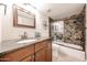 Bathroom featuring vanity, granite counters, and glass-enclosed tub at 7800 E Lincoln E Dr # 1102, Scottsdale, AZ 85250