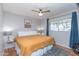 Cozy bedroom featuring a ceiling fan, neutral walls, a window, and a comfortable queen-size bed at 837 E Divot Dr, Tempe, AZ 85283