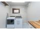 Bright laundry room featuring modern washer and dryer with butcher block countertop and designer-tile floor at 837 E Divot Dr, Tempe, AZ 85283