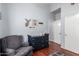 Cozy bedroom features wood floors, grey accent wall, and a dresser with an armchair at 8850 W Laurel Ln, Peoria, AZ 85345