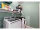 Well-organized laundry room features a washer, dryer and wire shelving, all in a brightly lit space at 8850 W Laurel Ln, Peoria, AZ 85345