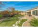 Artificial turf backyard with stone paver path, desert landscaping, and an outdoor kitchen at 891 W Palo Brea Dr, Litchfield Park, AZ 85340