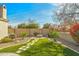 Well-manicured backyard with artificial turf, paver walkway, and outdoor fire pit at 891 W Palo Brea Dr, Litchfield Park, AZ 85340