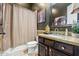 Bathroom featuring dark green walls, vanity with granite countertop, framed mirror, and shower with curtain at 891 W Palo Brea Dr, Litchfield Park, AZ 85340