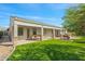 Exterior view of the home featuring a covered patio, outdoor kitchen, and manicured lawn at 891 W Palo Brea Dr, Litchfield Park, AZ 85340