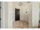 View of the foyer with a dark wood door, tan tile flooring, and modern light fixture at 891 W Palo Brea Dr, Litchfield Park, AZ 85340