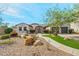 Charming home featuring desert landscaping, a stone pathway, and a spacious three-car garage at 891 W Palo Brea Dr, Litchfield Park, AZ 85340