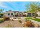 Charming home featuring desert landscaping, a stone pathway, and a spacious three-car garage at 891 W Palo Brea Dr, Litchfield Park, AZ 85340