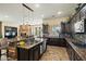 Large kitchen and island featuring stone accents, granite counters, wood cabinets and stainless appliances at 891 W Palo Brea Dr, Litchfield Park, AZ 85340