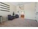 Neutral living room showing 2 chairs, a table, shelving, and an open door to the bathroom at 891 W Palo Brea Dr, Litchfield Park, AZ 85340