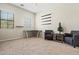 Bright living room space with 2 windows, a desk, shelving, two chairs, and carpet flooring at 891 W Palo Brea Dr, Litchfield Park, AZ 85340