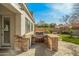 Built-in outdoor kitchen with stainless steel BBQ grill, stone accents, and bar seating at 891 W Palo Brea Dr, Litchfield Park, AZ 85340