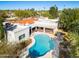 Aerial view of a home with a pool, patio area, and a red-tiled roof and lush landscaping at 9901 N 51St Pl, Paradise Valley, AZ 85253