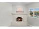 Bedroom fireplace with custom mantel and views of the outdoor pool through plantation shutters at 9901 N 51St Pl, Paradise Valley, AZ 85253