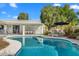 Sparkling swimming pool with lounge area and mature trees in a private backyard oasis at 9901 N 51St Pl, Paradise Valley, AZ 85253