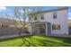 Spacious backyard featuring a lush lawn, mature tree, a screened-in patio, and block fence at 10146 W Watkins St, Tolleson, AZ 85353