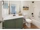 Bathroom featuring an olive vanity, decorative art, and a tub with white tiled walls at 10146 W Watkins St, Tolleson, AZ 85353