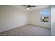 A bedroom featuring neutral carpet, a ceiling fan, and natural light from a window at 10146 W Watkins St, Tolleson, AZ 85353