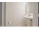 A half bathroom featuring a pedestal sink, mirror, and toilet paper holder at 10146 W Watkins St, Tolleson, AZ 85353