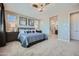 Comfortable main bedroom with a ceiling fan, carpeted floors, and an open doorway to an en suite bath at 10209 E Ursula Ave, Mesa, AZ 85212