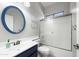 Bright bathroom with a sleek vanity, modern sink and faucet, stylish blue-framed mirror and a bathtub with sliding glass door at 10449 E Lomita Ave, Mesa, AZ 85209