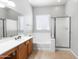 Bright bathroom featuring double sinks, a separate soaking tub, and a glass-enclosed shower at 10449 E Lomita Ave, Mesa, AZ 85209