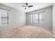 Bright, spacious bedroom with neutral carpet, ceiling fan, and ample natural light from large windows at 10449 E Lomita Ave, Mesa, AZ 85209