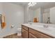 Bright bathroom featuring a dual sink vanity with modern faucets and wood-look flooring at 1052 W Capulin Trl, San Tan Valley, AZ 85140