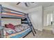 bedroom with a bunk bed, ladder, blue ceiling fan and white closet door at 1052 W Capulin Trl, San Tan Valley, AZ 85140