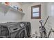 Clean laundry room featuring a front-load washer and dryer with an upper shelf at 1052 W Capulin Trl, San Tan Valley, AZ 85140