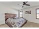 Bright main bedroom featuring a ceiling fan, neutral walls, carpet and brown wood window trim at 1052 W Capulin Trl, San Tan Valley, AZ 85140