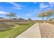 Scenic view of the community walking path with lush greenery and mature trees at 1052 W Capulin Trl, San Tan Valley, AZ 85140