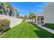 Backyard with long, manicured lawn, block fence, and covered patio at 10540 N 78Th Pl, Scottsdale, AZ 85258