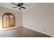 This light-filled bedroom features wood-look floors and an arched window with closed wooden shutters at 10540 N 78Th Pl, Scottsdale, AZ 85258