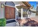 Inviting front entrance featuring a charming wood door, bay window and a welcoming terra cotta tile patio at 10540 N 78Th Pl, Scottsdale, AZ 85258