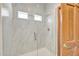 New marble tile shower enclosure with glass doors at 10540 N 78Th Pl, Scottsdale, AZ 85258