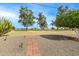 Expansive backyard with grass, trees, and a brick pathway, creating a picturesque outdoor space at 10846 W Crosby Dr, Sun City, AZ 85351