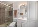 Bathroom featuring glass shower, white cabinets, single sink, and modern lighting at 10846 W Crosby Dr, Sun City, AZ 85351