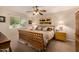 Cozy bedroom featuring a wood-frame bed, ceiling fan, and natural light at 10846 W Crosby Dr, Sun City, AZ 85351