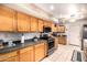 A kitchen with wooden cabinets, tile flooring, and stainless steel appliances at 10846 W Crosby Dr, Sun City, AZ 85351