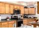 Well-lit kitchen with wood cabinets, modern stainless steel appliances, and tile backsplash at 10846 W Crosby Dr, Sun City, AZ 85351