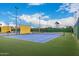 View of blue community tennis courts with green trim, featuring a net and perimeter fencing at 10846 W Crosby Dr, Sun City, AZ 85351