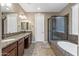 Bright bathroom with dual sinks, granite counters, large mirror, and a glass shower at 1101 W Oleander Ave, Queen Creek, AZ 85140