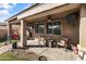 Relaxing covered patio features a ceiling fan, outdoor seating, and stylish decor at 1101 W Oleander Ave, Queen Creek, AZ 85140